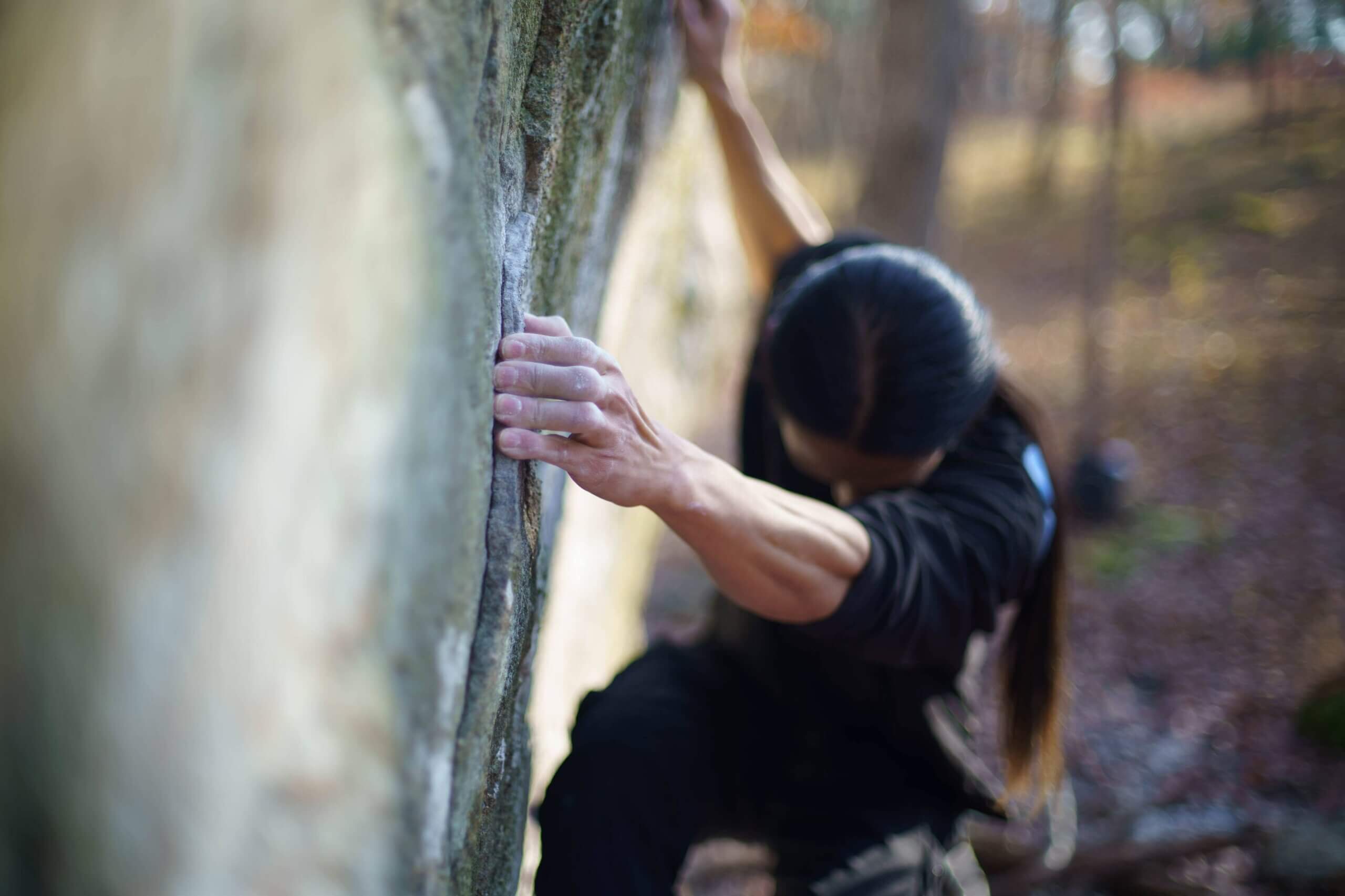 Sunna Shinn climbing an outdoor boulder.