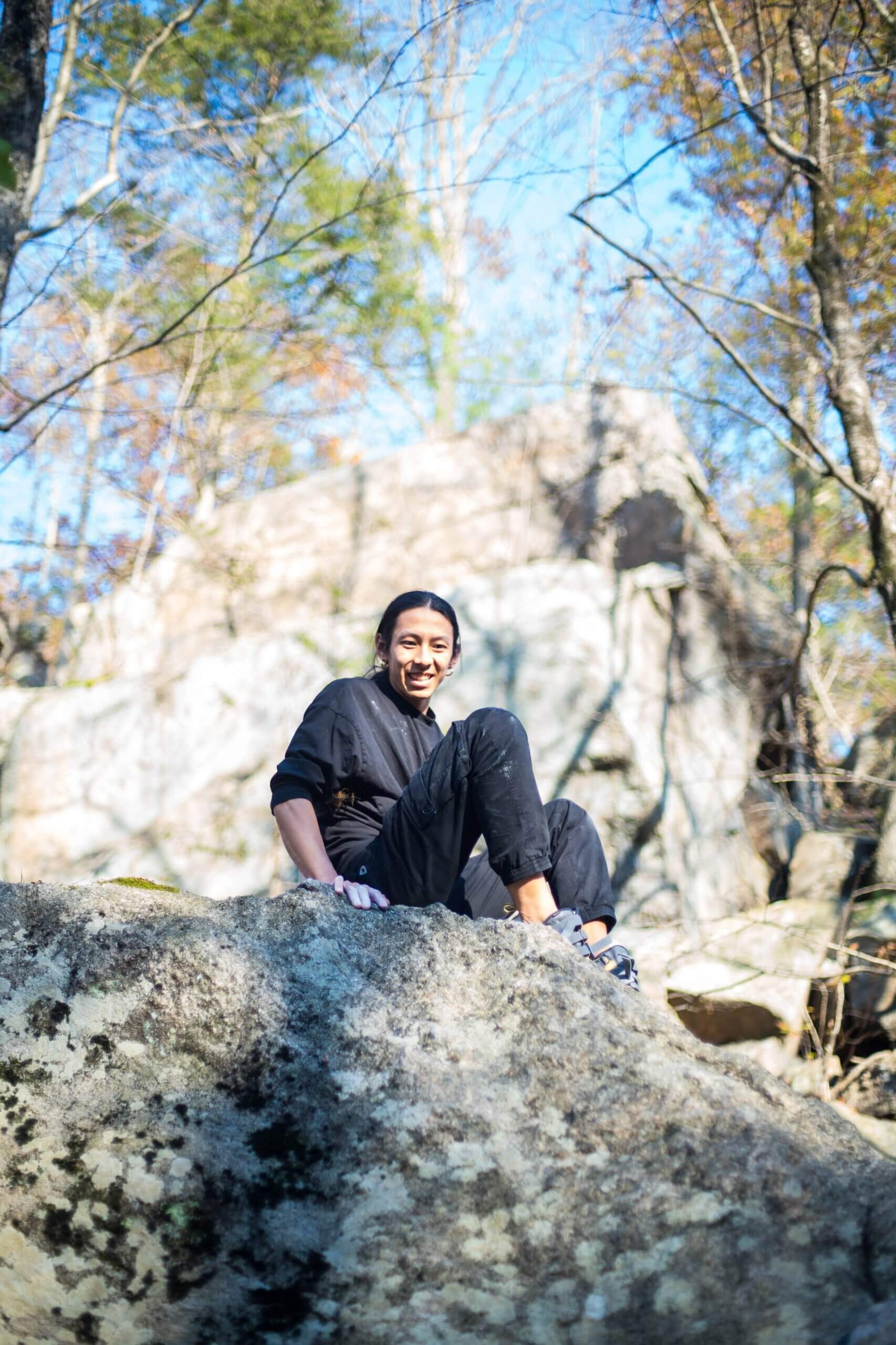 Sunna Shinn sitting on top of a boulder.